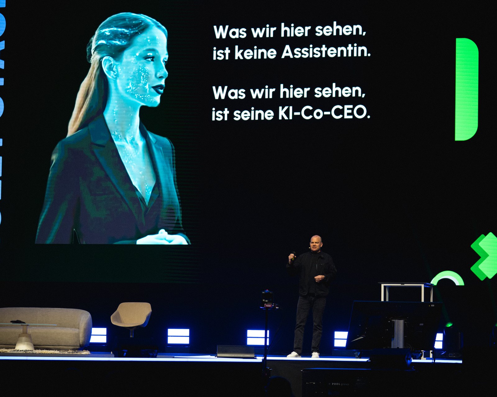 Christian Steiger auf der Violet Stage bei data:unplugged, auf der Leinwand Lena und der Satz „Was wir hier sehen, ist seine KI-Co-CEO.“