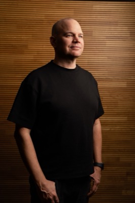 Christian Steiger, Porträt vor Holzwand, Halbprofil